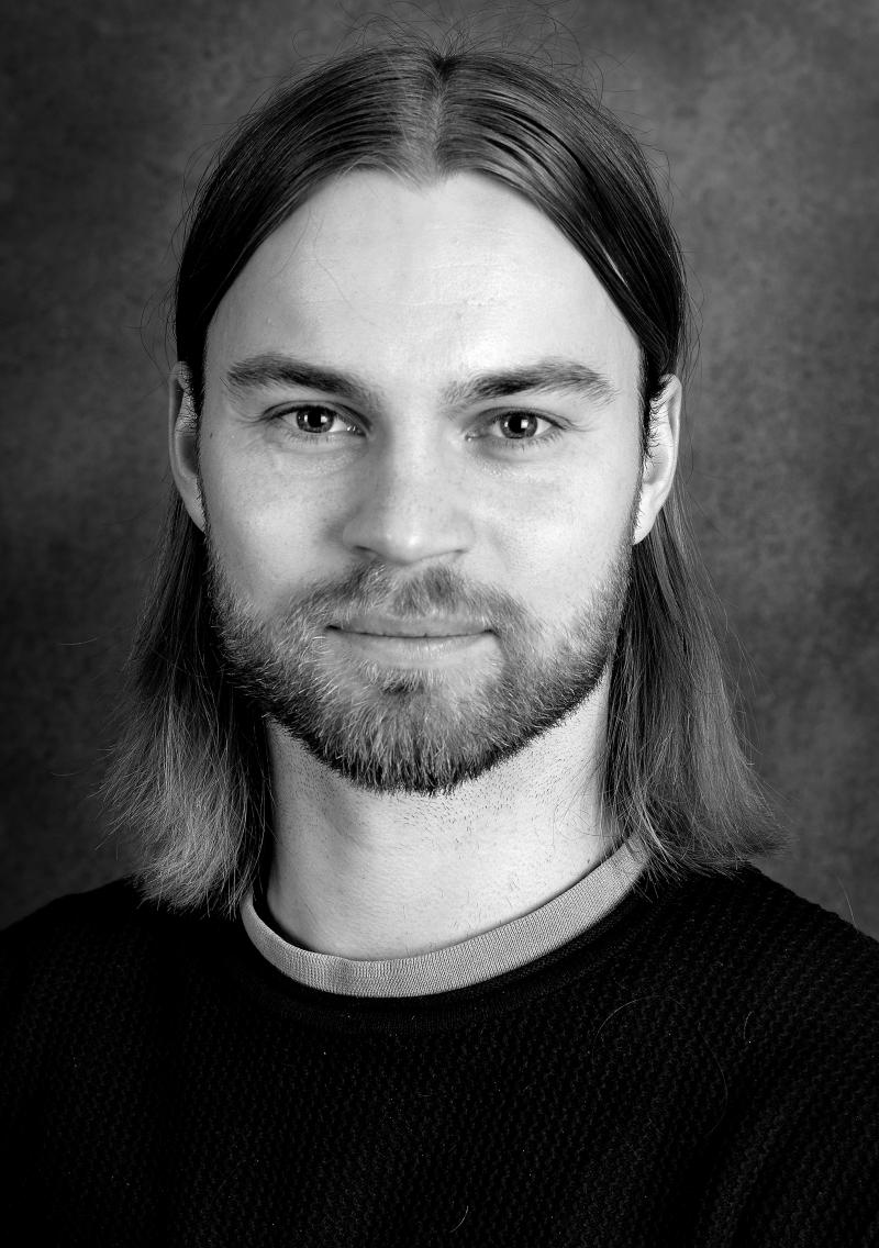 Uppsala Stadsteater Porträttbild, svartvit bild på person med axellångt hår och skägg