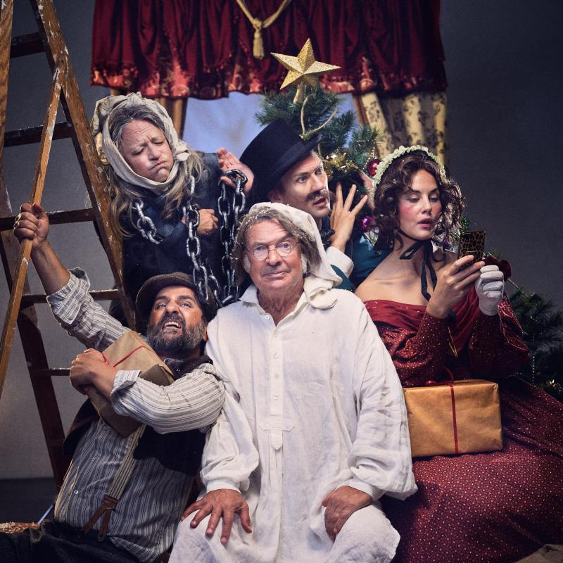 Kaotiskt gruppfoto på skådespelare. En ramlar in i den andre, en lösmustasch sitter löst, en tittar i telefon.