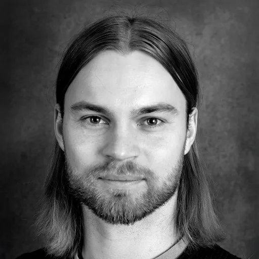 Porträttbild, svartvit bild på person med axellångt hår och skägg