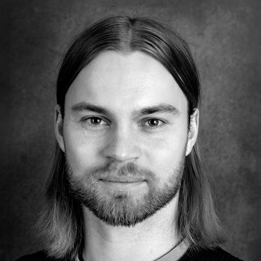 Porträttbild, svartvit bild på person med axellångt hår och skägg