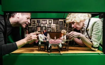 Två personer på varje sida håller i barbiedockor som sitter vid ett bord.