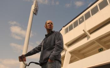 Foto Johan Sundell Person står med cykel utanför fotbollsstadion