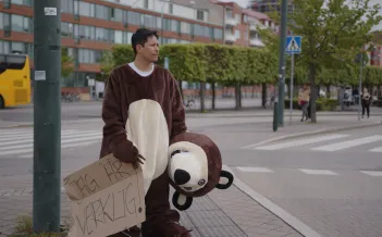 Man i nallebjörnskostym står vid Södervärns bussstation