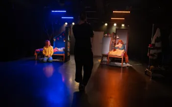 En fotograf i siluett i förgrunden som fotar en föreställning på en liten scen
