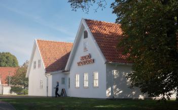 Exteriör bild Malmö Stadsteater Rosengård. Vitputsat hus med tegeltak, stor skylt Malmö Stadsteater