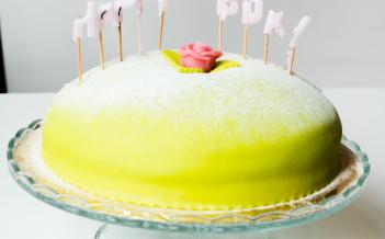 en prinsesstårta med utbrunna ljus som bildar Happy Bday