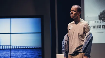 Man står med jeansjacka som kasat över axlarna ner över armarna
