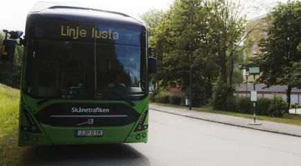 Buss med texten "Linje lusta" står stilla vid hållplats